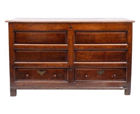 An 18th Century oak dower chest:, with a rectangular hinged moulded top, having a fielded panel front with two short drawers 