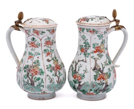 A matched pair of Chinese famille verte jugs and covers: of baluster form with Dutch gilt-metal mounts, the bodies moulded wi