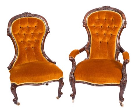 A Gentleman's Victorian carved walnut armchair and a lady's matching chair:, the cartouche-shaped upholstered button down pan