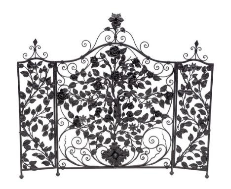 A painted wrought iron three fold firescreen, 20th century,: the arched central section and subsidiary panels all with flower