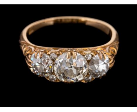 A three stone diamond ring,: the central old brilliant cut diamond, estimated to weigh 1.20 carats, claw set between two old 