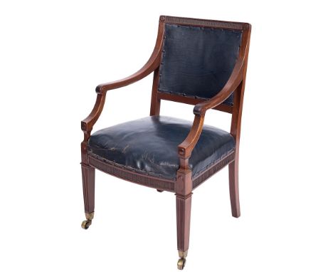An Edwardian mahogany library armchair:, the upholstered panel back with fluted top rail, having shaped arm supports and bowe