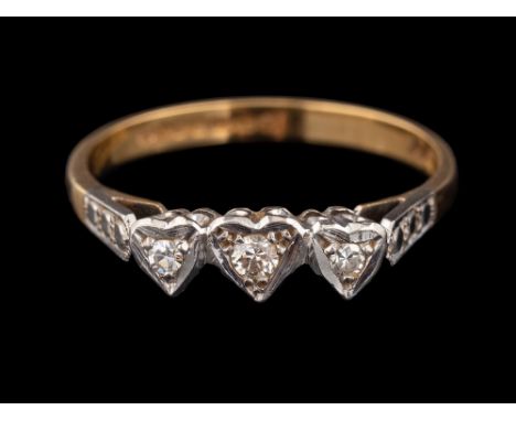 An 18 carat gold and diamond ring,: the central brilliant cut diamond between two eight cut diamonds in heart shaped settings