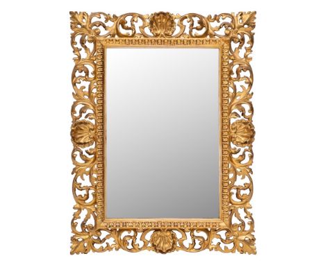 A carved giltwood Florentine frame mirror:, of rectangular shape, the plate within a fluted slip and pierced acanthus scroll 