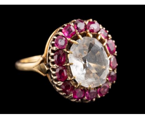 A rock crystal and ruby cluster ring,: the central oval cut rock crystal within a surround of cushion-shaped rubies, ring siz