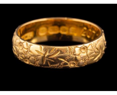 A 22 carat gold ring,: the band with chased foliate decoration, stamped 22 with full London hallmarks for 1967, ring size P, 