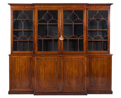 An early 19th Century mahogany breakfront library bookcase:, the upper part with a moulded cornice, fitted with adjustable sh