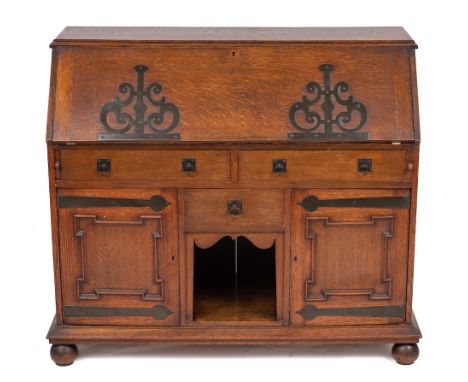 An Arts and Crafts oak bureau, circa 1900,: with retail plaque for P.E.GANE, COLLEGE GREEN, BRISTOL, the fall front applied w