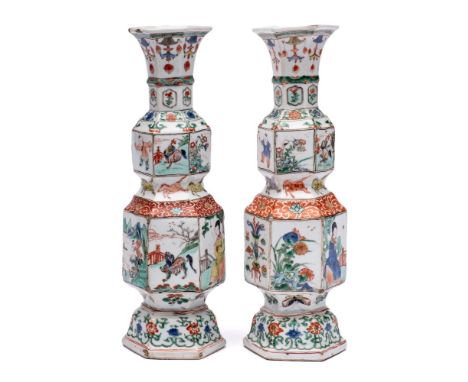 A pair of Chinese famille verte hexagonal section double-gourd vases: painted with alternating panels of figures in gardens, 