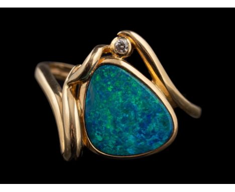 A 14 carat gold boulder opal and diamond ring,: the pear shaped boulder opal in a collet setting, with a brilliant cut diamon