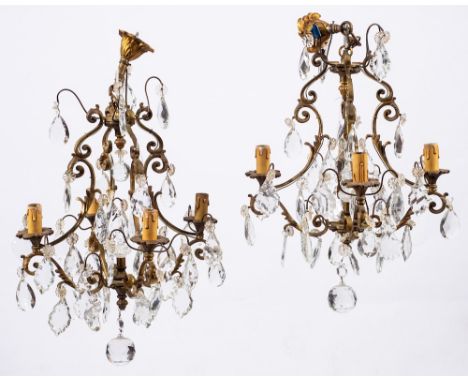 A pair of gilt metal and cut glass hung four-light chandeliers in Louis XV style, early 20th century,: the electrical fitting
