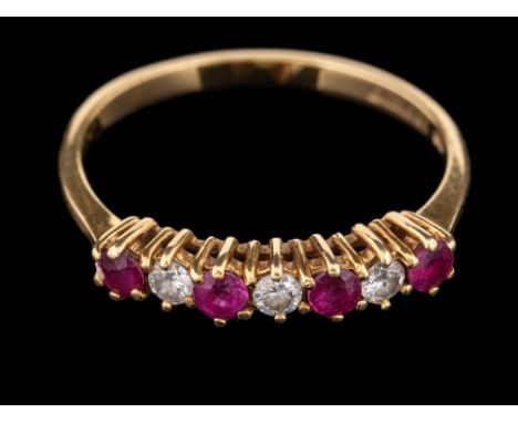 An 18 carat gold ruby and diamond ring,: set with alternating circular cut rubies and brilliant cut diamonds, stamped 750 wit