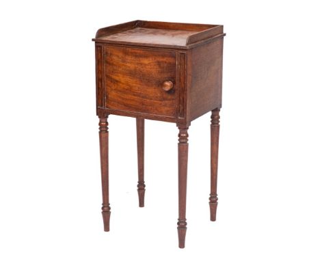An early 19th Century mahogany pot cupboard:, with reeded edge and three quarter ledge gallery, enclosed by a panel door, on 