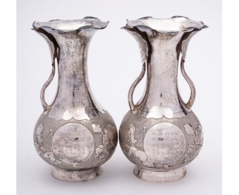 A pair of Chinese silver vases, stamped marks: bears Chinese inscription, of ovoid outline, the handles in the form of leaf s