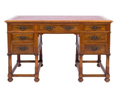 An Edwardian walnut kneehole desk:, the rectangular moulded top inset with a panel of faux leather, fitted with a central dra