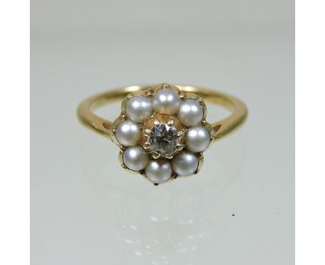 An unmarked gold pearl and diamond daisy set cluster ring, tests 18 carat