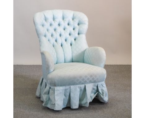 A blue upholstered button back armchair