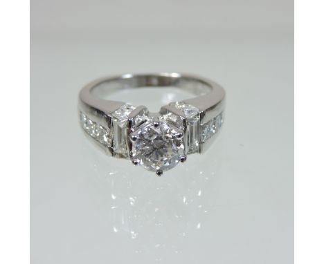 An 18 carat white gold diamond solitaire ring, the central stone approx 1.0 carat, flanked by diamond shoulders, approx 0.5 c