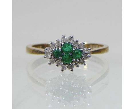 A 9 carat gold diamond and emerald cluster ring, boxed 