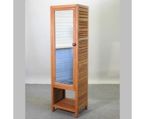 A modern slatted light oak cabinet, enclosed by a mirrored door, 50cm