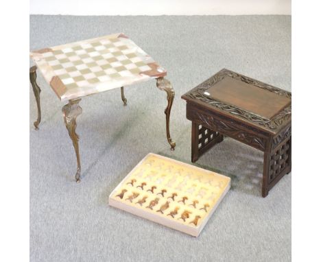 An onyx chess table and matching chess set, boxed, together with an Indian carved hardwood folding occasional table