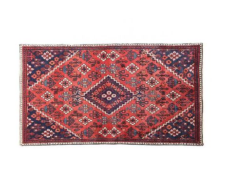 PERSIAN RUG WITH RED AND NAVY BACKGROUND AND AN AZTEC DESIGN.68 X 39 INCHES.IN GOOD CONDITION.