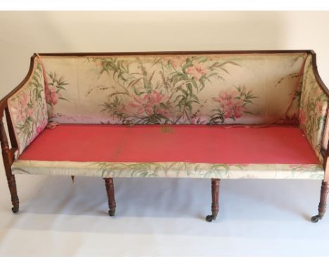 Edwardian Regency style mahogany sofa, with reeded frame and eight legs with brass sockets and casters, upholstered back and 