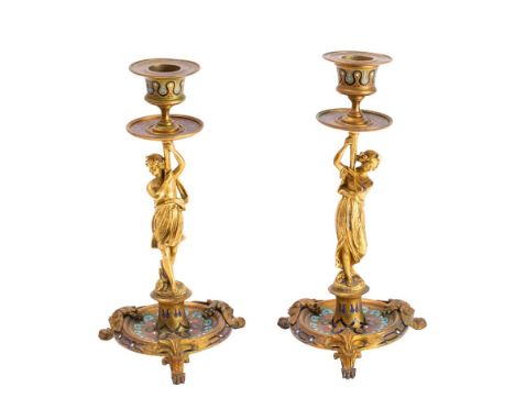 A pair of Louis XV style gilt bronze and champleve enamel candlesticks: with urn-shaped sconces supported by neo-classical fe