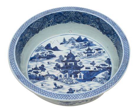 A large Chinese blue and white basin painted with an extensive pagoda lake landscape within an elaborate diaper and foliate b