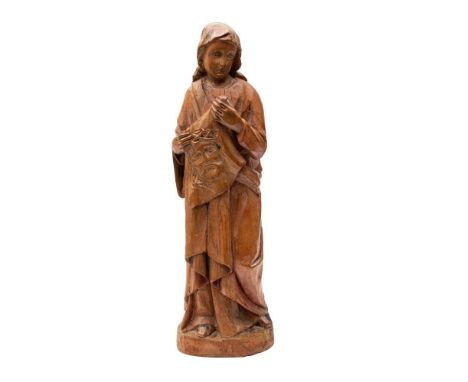 A North European sculpted softwood model of Saint Veronica holding her veil, 18th century, portrayed standing and fully drape