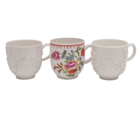 A group of three Bow coffee cups two in the white, one polychrome, the first two moulded with prunus sprays, one with incised