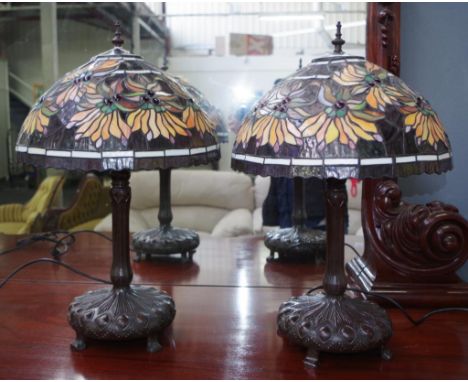 Pair Tiffany style metal table lamps with shades each with moulded metal base, and decorative lamp shades, fitted for electri