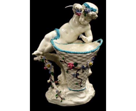 Vintage Continental Figural ceramic vase depicting a reclining Putti with basket form vase, applied floral decoration, (hairl