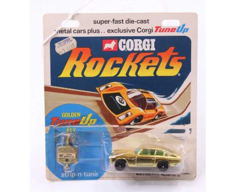 A Corgi Rockets Aston Martin DB6 in gold with green windows and a yellow interior, with golden Tune Up key, the model blister