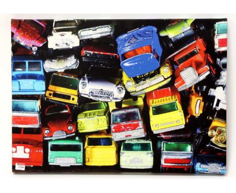 A modern reproduction canvas print depicting a Matchbox scrapyard, of various playworn models, to measure 50x70cm