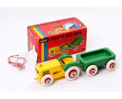 A vintage Brio of Sweden No. 31014 Tractor and Trailer made from wood, in yellow and green with white rubber tyres and pull-a