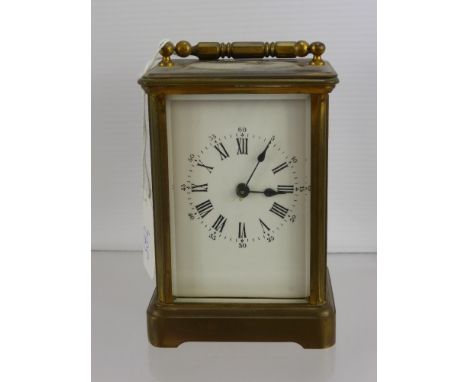 A Brass Carriage Clock, with white enamel face, the carriage clock having numeric and Roman numerals with clubs and diamonds 