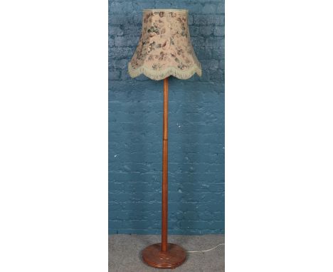 A mahogany standard lamp on circular base.  