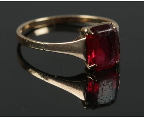 A 9ct gold ring with central red stone. Size M. Total weight: 1.32g.  