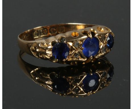 A 18ct gold blue stone &amp; diamond ring in boat shaped setting, size N. 2.59g.  