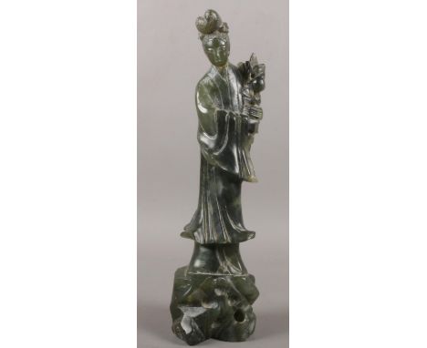A carved spinach Jade oriental figure. 25.5cm height.  damage to head been glued