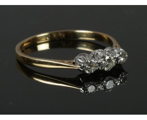 A vintage 18ct gold three stone diamond ring, size T. 2.74g.  