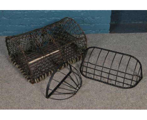A vintage lobster trap with iron frame along with two hanging baskets.  