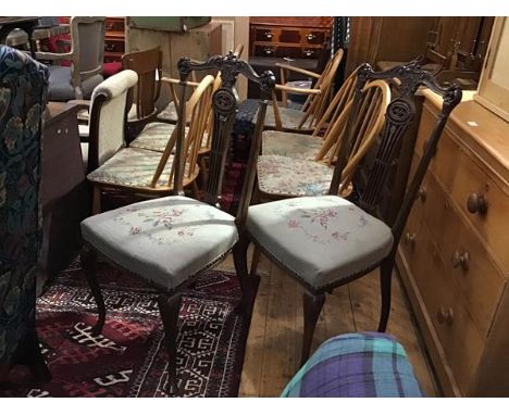 A pair of Edwardian mahogany pierced and carved spar back side chairs with stuffover seats, in floral tapestry,  on square ta