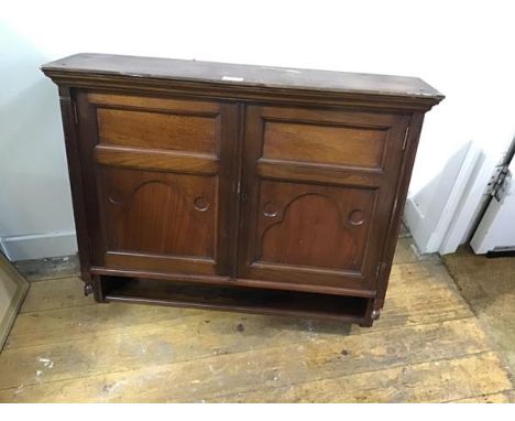 An Edwardian walnut wall cabinet, the moulded top above a pair of inset fielded panel doors, enclosing a shelved interior, wi