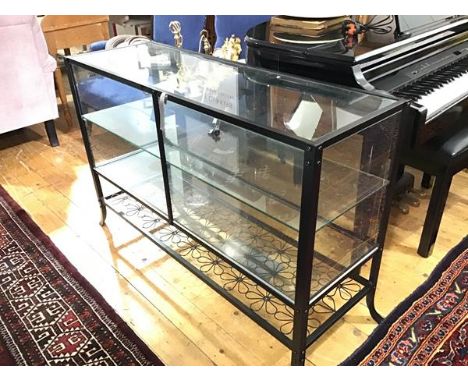 An anodised metal counter style display cabinet, with twin panel doors, and interior glass shelf and wrought iron daisy patte