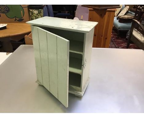 An Edwardian tongue and groove style miniature green painted cabinet with shelved interior, raised on plinth base with bracke