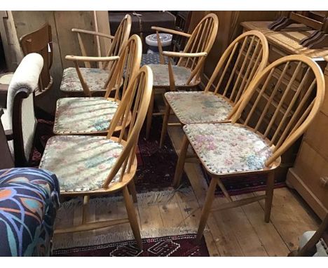 A set of six Ercol style ash spindle back arched dining chairs with later upholstered seats, raised on turned splay supports 