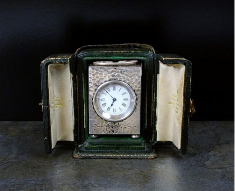 An Edwardian hammered silver cased timepiece, W & G Neal, London 1904 the circular white enamel dial with black Roman numeral