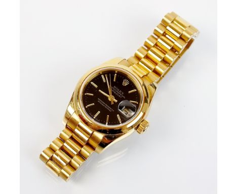 A lady's 18ct gold Rolex Oyster Perpetual Datejust Chronometer Wristwatch, the black dial with gold, with attached President 
